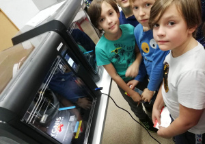 Uczniowie klasy 4a obserwujący proces drukowania rowerów 3D.
