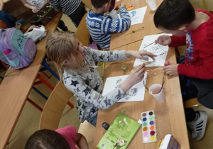 Uczniowie klasy 1b podczas twórczej pracy z wykorzystaniem farb.
