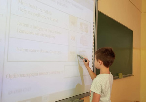 Uczeń pisze na tablicy.